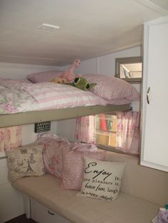 bunk beds with pillows and stuffed animals on them in a room that looks like a child's bedroom