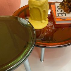 a table with a small yellow animal on it's side, and a green chair next to it