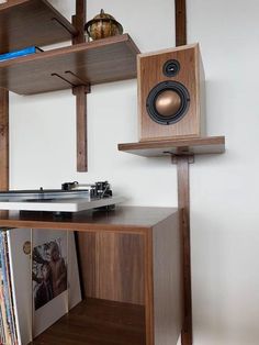 a record player sitting on top of a wooden shelf