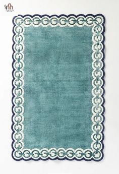 an area rug with blue and white trimmings on the edges, in front of a