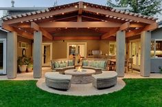 an outdoor living area with couches, tables and fire pit in the middle of it