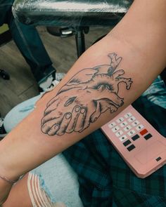 a person with a tattoo on their arm holding the hand of another person's heart