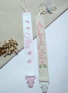 two lanyards that say alice and one with flowers on them are sitting next to each other