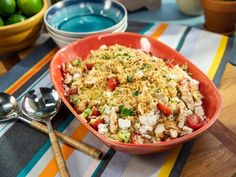 a bowl filled with rice and vegetables on top of a table next to bowls of limes