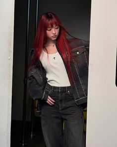 a woman with red hair is standing in an open doorway and looking at the camera