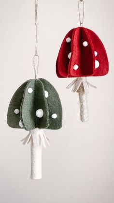 two felt mushroom ornaments hanging from strings