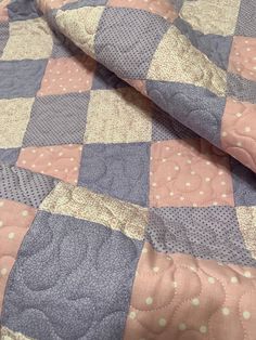 a pink and blue quilt with polka dots on it