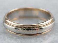 two gold wedding bands on top of each other, one with a zipper in the middle