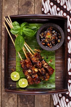 an overhead view of some food on a plate with chopsticks and garnishes