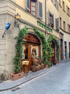 the outside of a restaurant with ivy growing on it's walls and windows, along an empty street