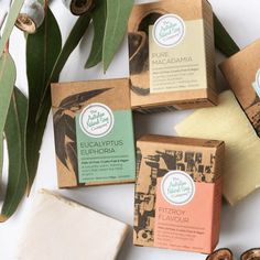 four soap bars sitting on top of each other next to some green leaves and flowers