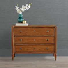 a wooden dresser with white flowers on top