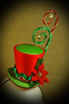 a green top hat with red flowers on it and a string attached to the top