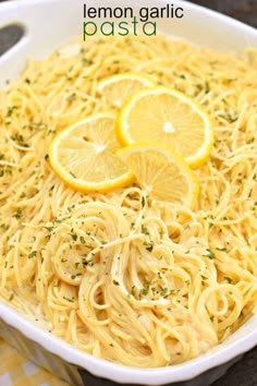 lemon garlic pasta in a white bowl with sliced lemons