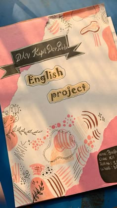 an english project written in black ink on a pink and white paper with floral designs