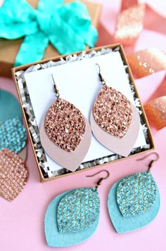 two pairs of glitter heart shaped earrings in a gift box next to some other items