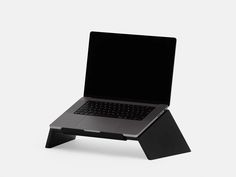 an open laptop computer sitting on top of a black stand