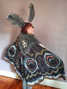 a woman in a butterfly costume with feathers on her head