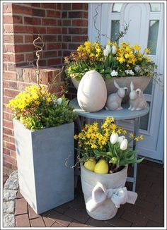 two cement planters with yellow flowers in them