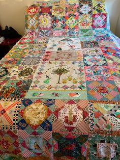 a bed covered in lots of colorful quilts