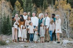 a large family poses for a photo in the woods