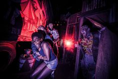 group of people dressed up as zombies in dark room with red light coming from behind