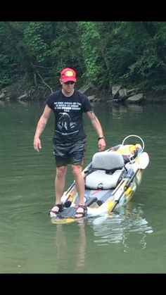 a man standing on top of a raft in the water next to a small boat