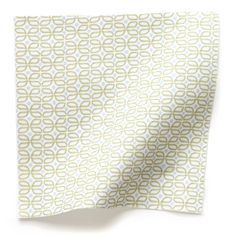 a white and green patterned napkin on top of a table