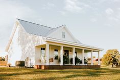 a white house sitting on top of a lush green field