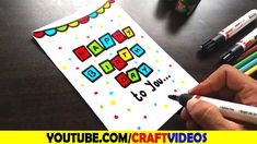 someone is writing happy birthday to you on a card with markers and crayons