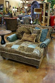 a living room filled with furniture and lots of pillows on top of it's couches