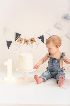 a baby sitting in front of a cake