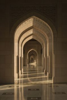 an archway in the middle of a building with marble flooring and walls on both sides