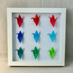 origami birds displayed in a white frame