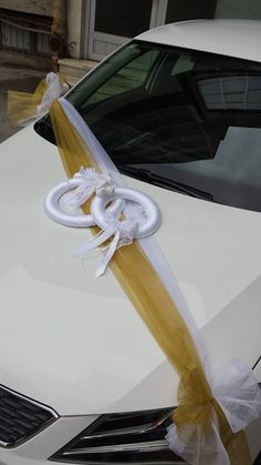 a white car with a yellow ribbon tied to it