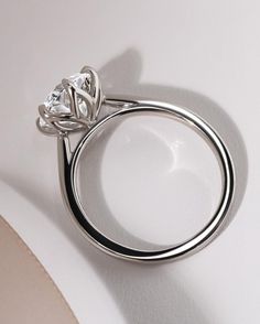 a diamond ring sitting on top of a white surface