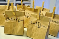 brown paper bags with drawings on them sitting on a table