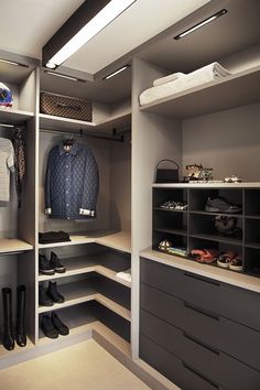 an organized walk in closet with shoes and bags