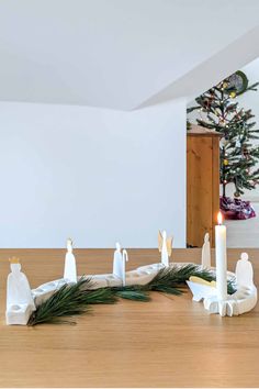 candles are sitting on the table in front of a christmas tree with angel figurines