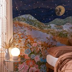 a room with a bed, night sky and flowers painted on the wall behind it