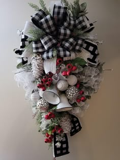 a christmas wreath hanging on the wall next to a white plate and silverware holder