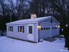 a small white building with lights on it's roof in the middle of winter