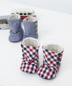 two pairs of baby shoes sitting on top of a table