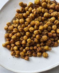 a white plate topped with nuts on top of a table