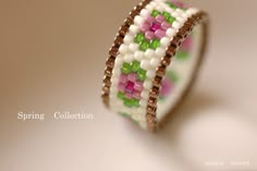 a close up of a beaded bracelet on a white surface with the words spring collection written below it