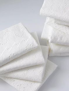 six white napkins are stacked on top of each other, with embellishment