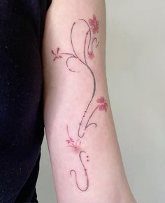 a woman with a tattoo on her arm that has vines and flowers growing out of it