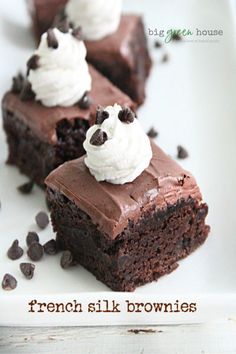 three pieces of chocolate cake on a plate with whipped cream and chocolate chips around them