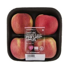 four red apples in a black container on a white background with a label for them