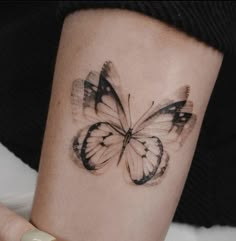 a woman's arm with a butterfly tattoo on it